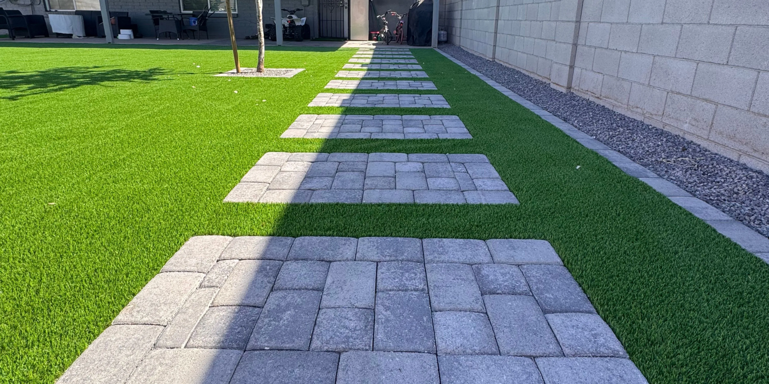Paver pathway across artificial grass lawn