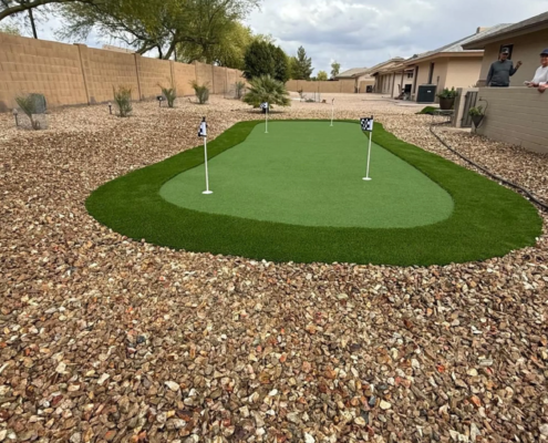 Backyard artificial turf putting green with flags