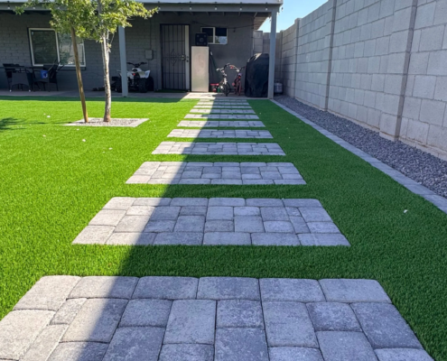 Backyard with turf and stepping stone path.