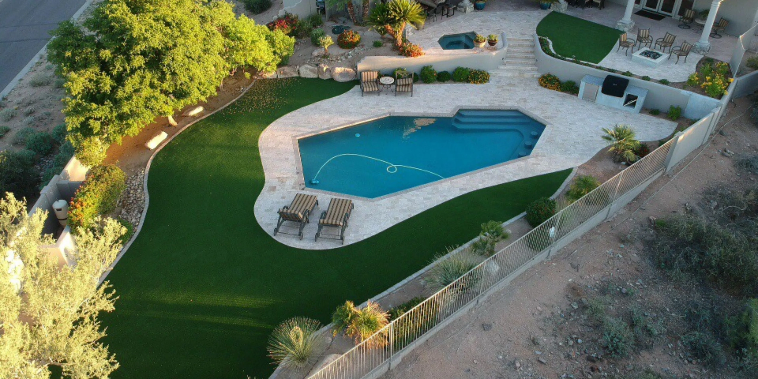 Aerial view of backyard pool with landscaped artificial turf lawn