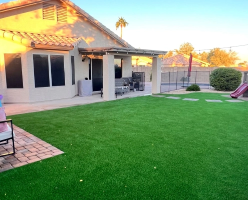 Backyard with turf, patio, and kids’ playset.