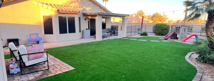 Backyard with turf, patio, and kids’ playset.