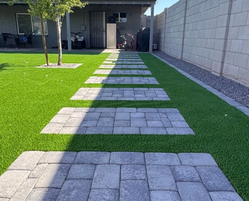 Stepping stone path on artificial grass beside a house