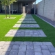 Stepping stone path on artificial grass beside a house