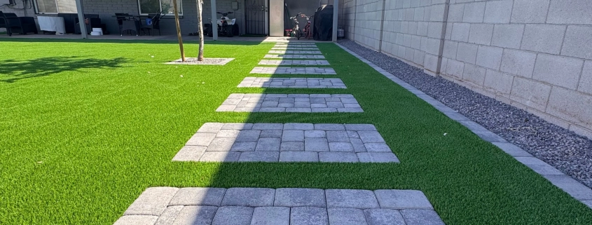 Stepping stone path on artificial grass beside a house