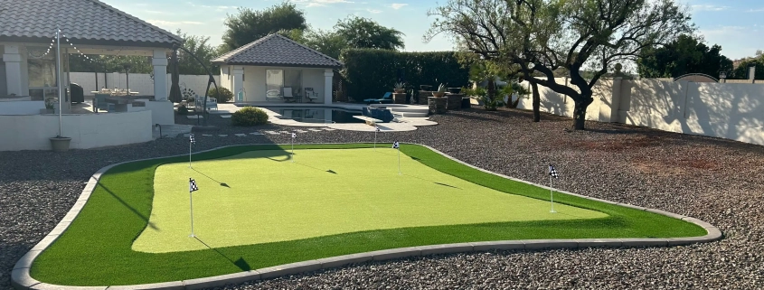 Backyard with putting green, patio area, and desert