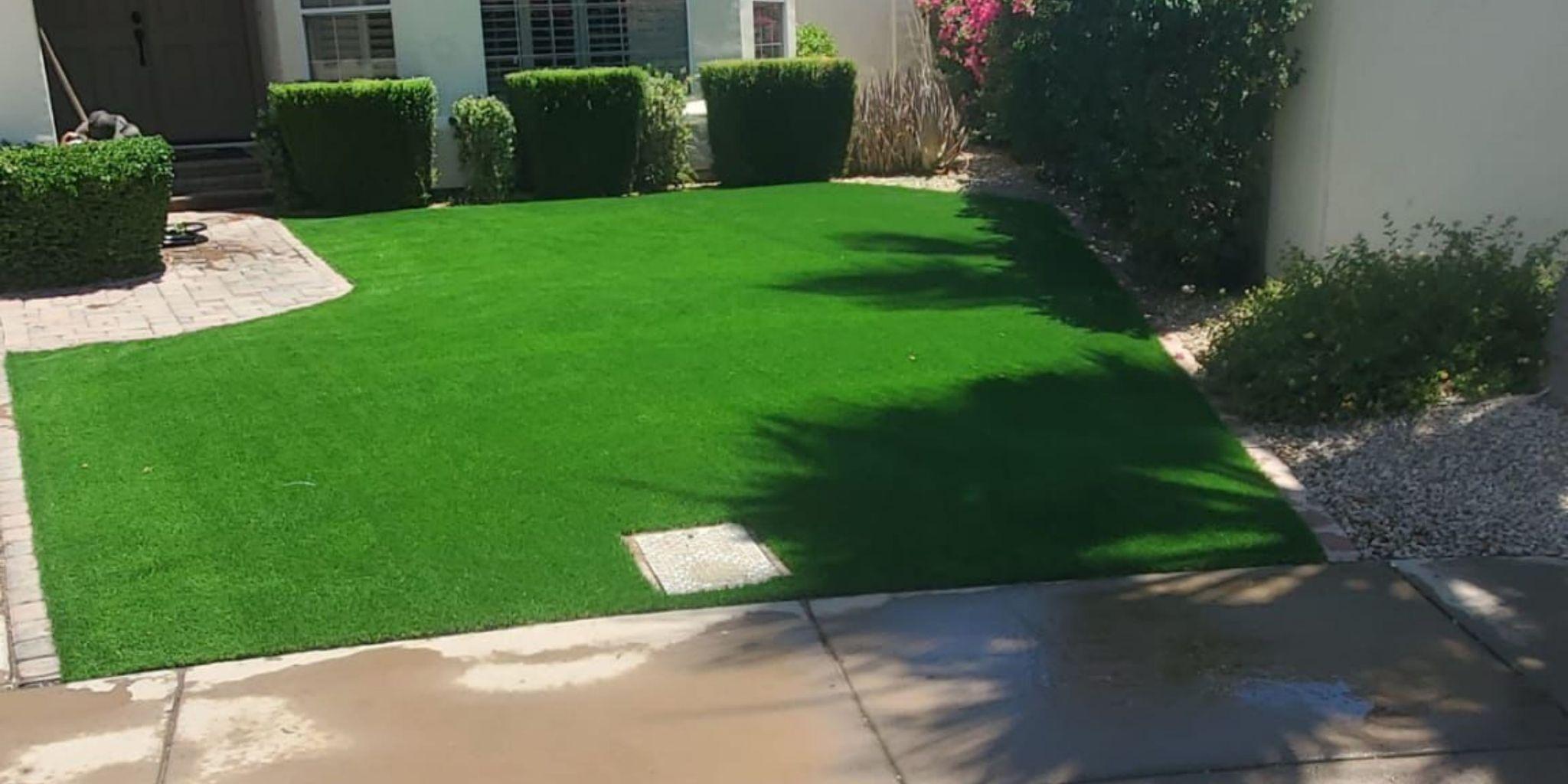 Artificial grass lawn with trimmed hedges.
