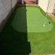 Backyard artificial turf putting green with two golf holes