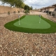 Artificial backyard putting green installation.
