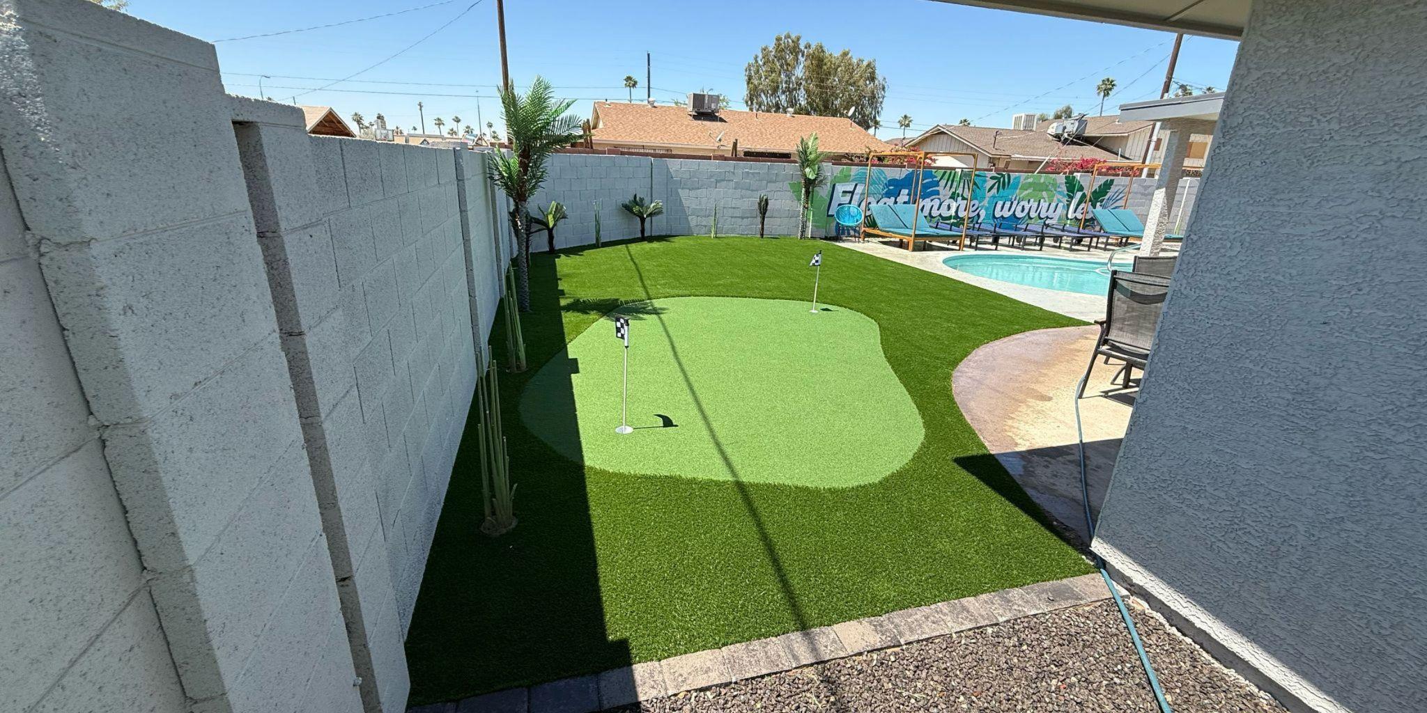 Backyard putting green with palm trees and patio.