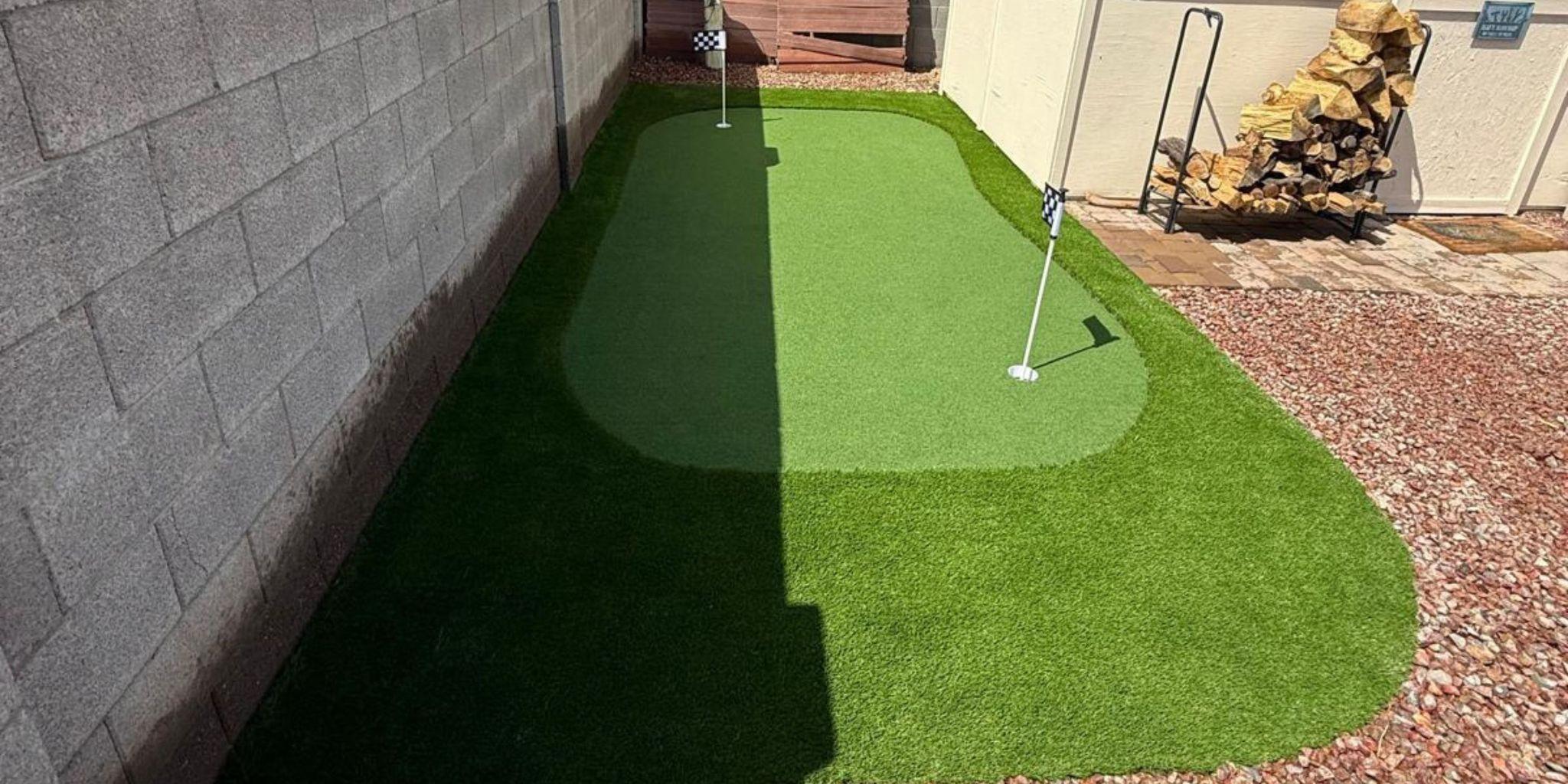 Small artificial putting green beside a concrete wall 

