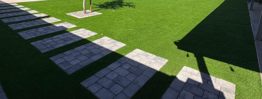 Stepping stones across a green lawn.
