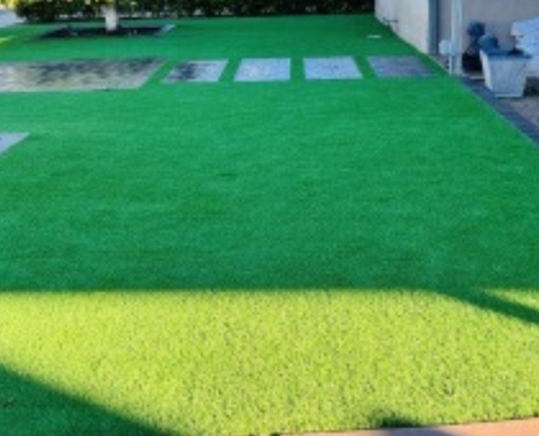 Green artificial grass lawn with stepping stones
