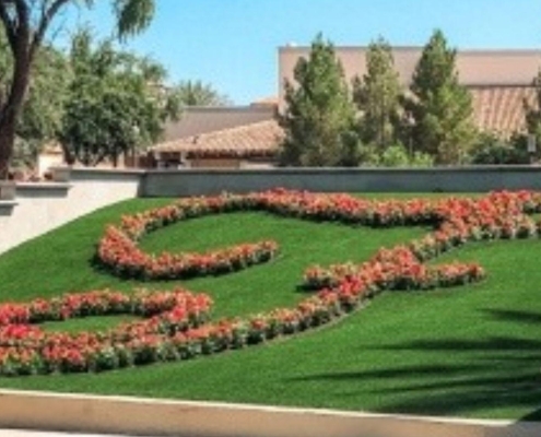 Landscaped fake grass lawn with red flower patterns