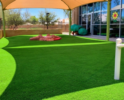 Outdoor artificial-turf play area with shade canopy