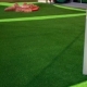 Playground with green artificial turf and white play bars